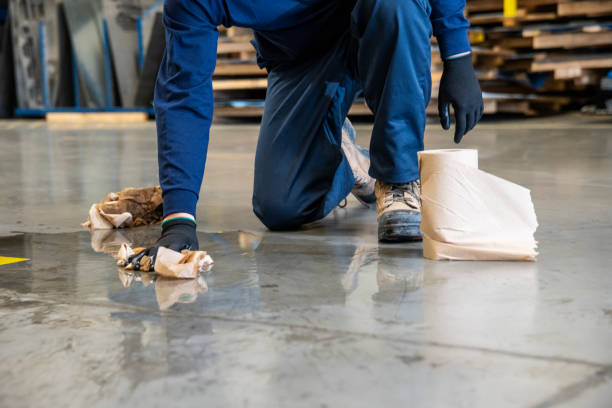 un travailleur de sexe masculin nettoyage un danger de glissement sur le sol d’une installation industrielle. - nettoyage fin de chantier photos et images de collection