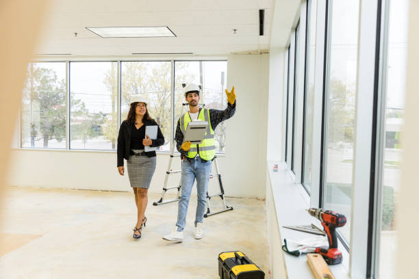 le contremaître superviseur rencontre l’employée municipale pour confirmer l’échéancier du nouveau bâtiment - nettoyage fin de chantier photos et images de collection